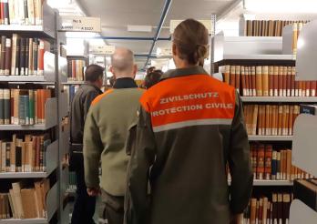 Membres de la protection civile de dos dans une bibliothèque