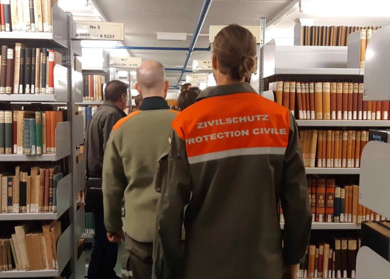Membres de la protection civile de dos dans une bibliothèque